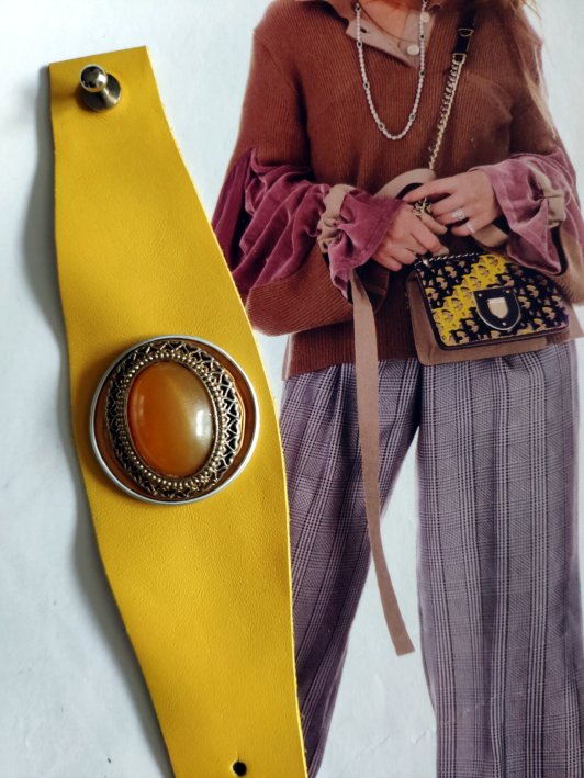 Bracelet Manchette (bras ou cheville) cuir véritable de couleur jaune moutarde, agrémenté d'un élément de récupération . Cuir très souple, adaptable à la taille du poignet (6 trous) . Longueur totale de la manchette : 24.5cm