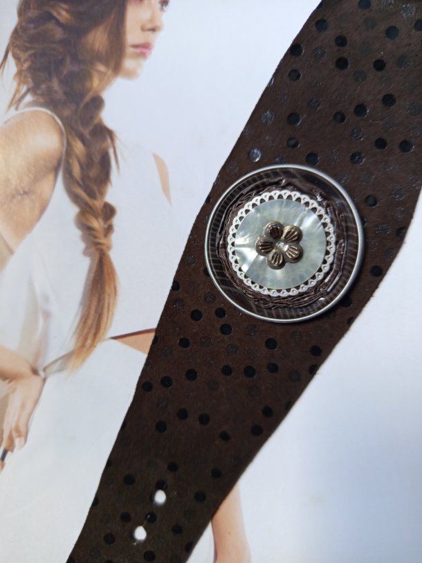 Bracelet Manchette (bras ou cheville) cuir véritable agrémenté d 'un élément de récupération . Cuir très souple, adaptable à la taille du poignet (6 trous) . Longueur totale de la manchette : 24.5cm