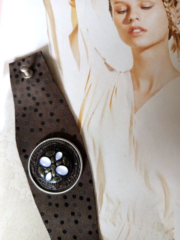 Bracelet Manchette (bras ou cheville) cuir véritable agrémenté d 'un élément de récupération . Cuir très souple, adaptable à la taille du poignet (6 trous) . Longueur totale de la manchette : 24.5cm