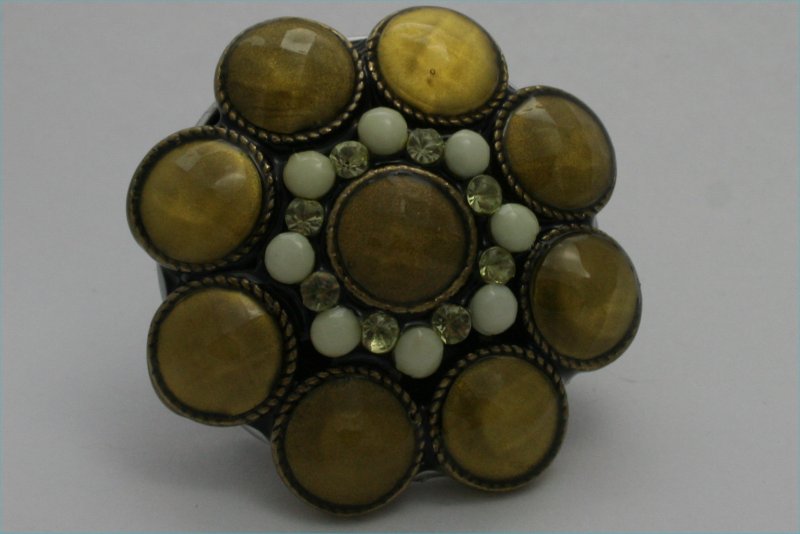 broche cabochons moutarde , perles beige clair , sur fond de capsule noire. diamètre de la capsule : 3.5cm