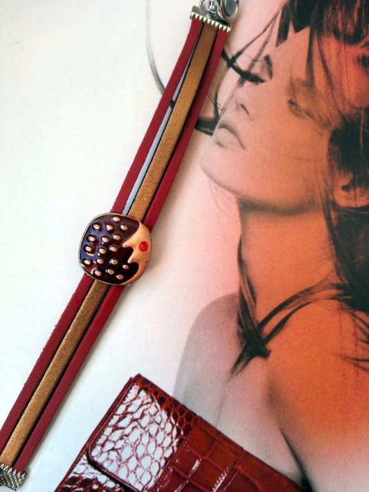 couleurs chaudes , rouge et brun cuivré,  pour ce bracelet 3 brins de cuir et décor métal émaillé. fermoir aimanté
