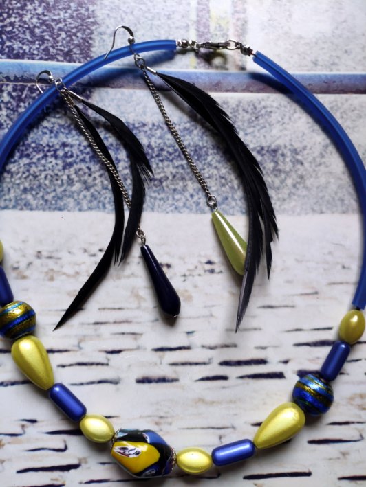 Offre duo: collier aux très jolies perles bleues et jaunes , beaucoup de raffinement et de lumière, associé à des boucles très légères, plume et perles bleu marine pour l'une, jaune pour l'autre ,  pour oreilles percées