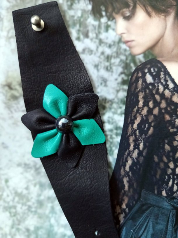 Bracelet Manchette (bras ou cheville) cuir véritable agrémenté d 'une fleur de cuir de récupération . Cuir très souple, adaptable à la taille du poignet (6 trous) . Longueur totale de la manchette : 24.5cm
