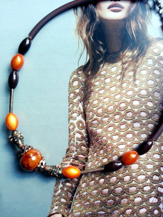 collier capsule ras de cou , à dominante brun-orange, très jolie perle centrale en céramique, monté sur câble